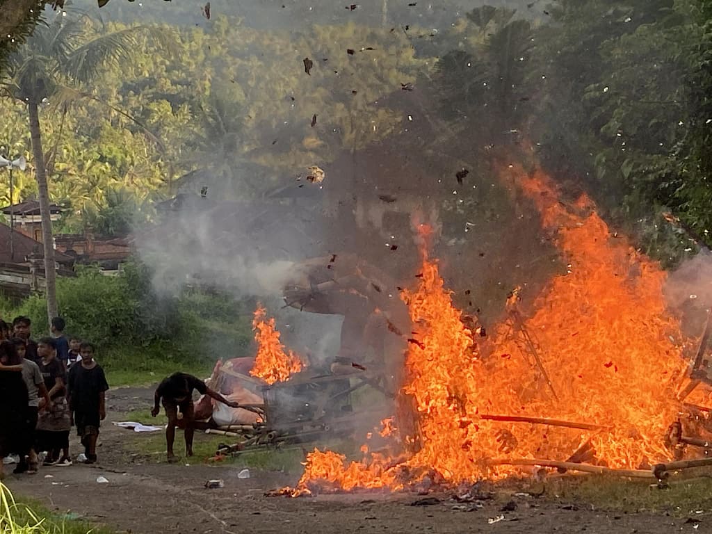 Hořící oheň a pálení zbytků soch Ogoh-Ogoh na odbočce ke hřbitovu na Bali.