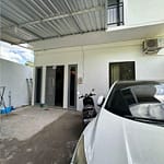 Tři fotografie z osobní prohlídky lokálního domu k pronájmu na Bali ukazující vjezdovou bránu, parkovací stání a kuchyň.
