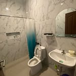 Série fotografií exteriéru a interiéru čistého dvoupodlažního domu v bezpečné rezidenční čtvrti v Sanuru na Bali. Ukázka světlé ložnice, moderní koupelny a upravené ulice.