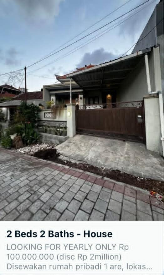Screenshot online inzerátu na dlouhodobý pronájem domu na Bali. Nabídka ukazuje dům se 2 ložnicemi a vjezdovou bránou za cenu 100 milionů indonéských rupií ročně.